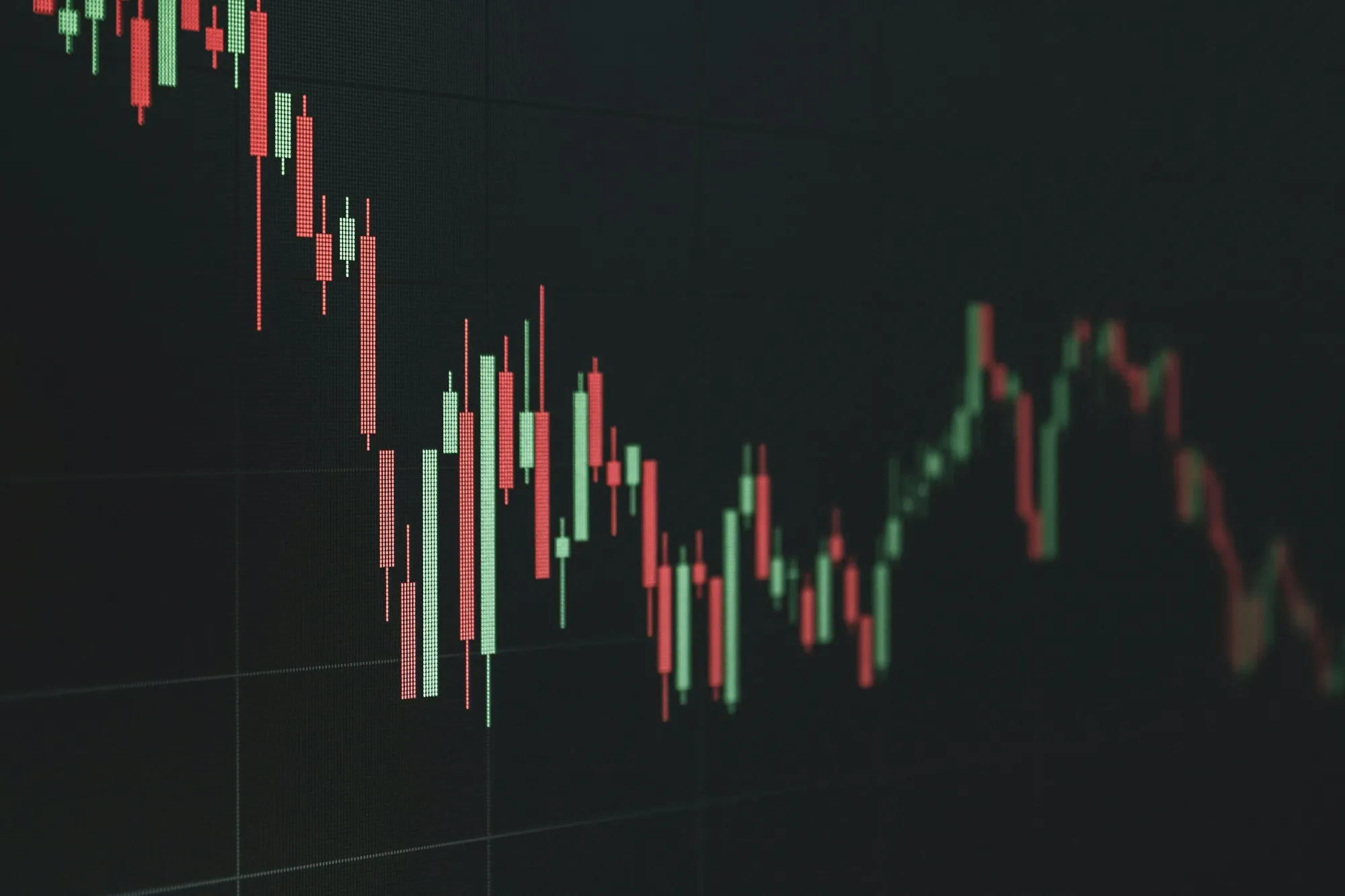A sharply falling candlestick chart on a dark screen